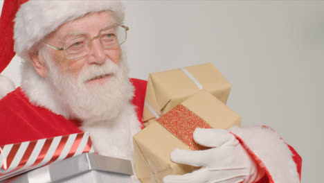 Close-Up-Shot-of-Santa-Walking-Into-and-Out-of-Frame-Holding-Gifts